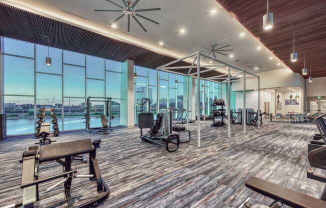 A gym with wooden floors and a variety of exercise equipment.