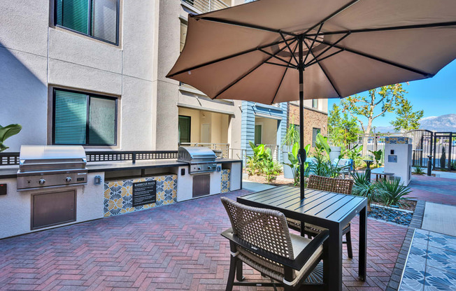 A patio with a table and chairs under an umbrella.