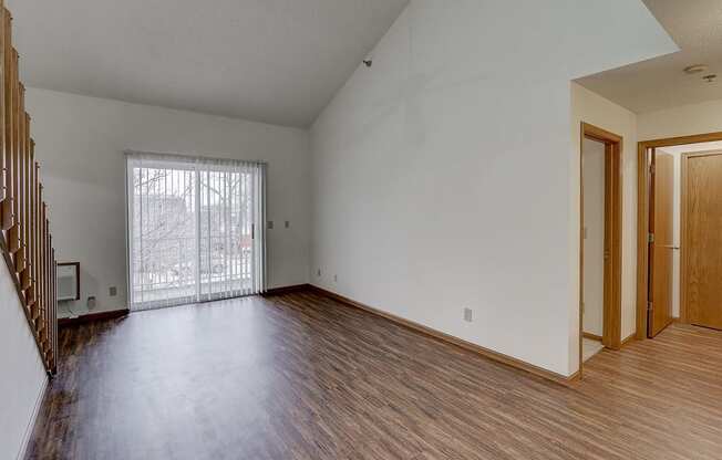 the living room of an empty house with wood flooring