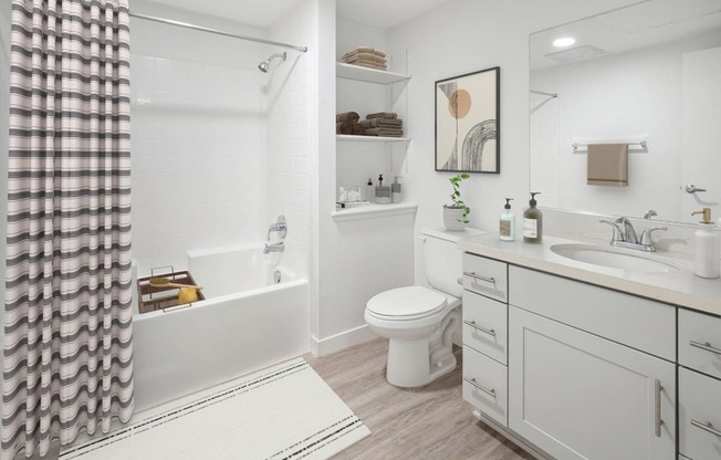 a white bathroom with a shower toilet and sink