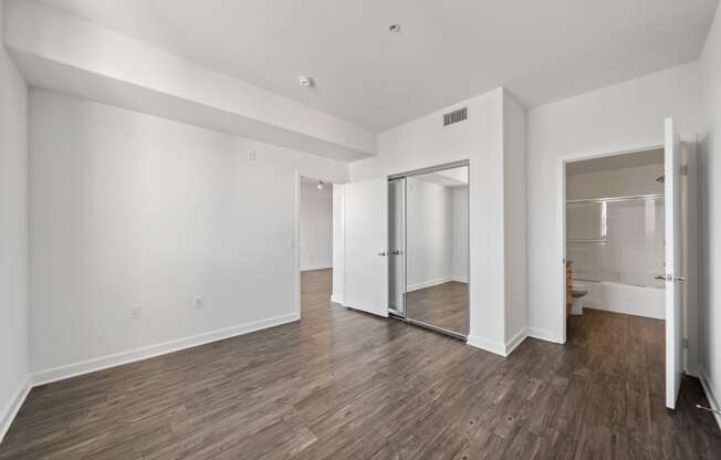 a living room with white walls and a sliding glass door to a bathroom