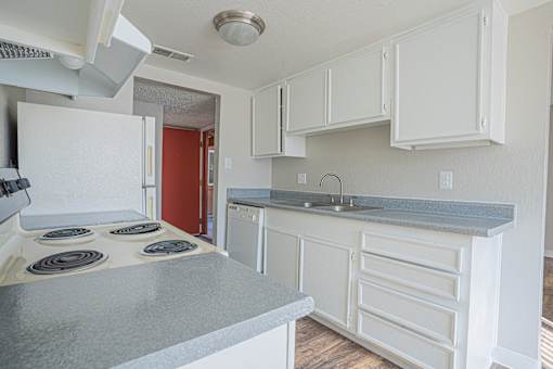 a kitchen with white cabinets and a stove and a sink at Parkside Gardens Apartments, Sparks Nevada