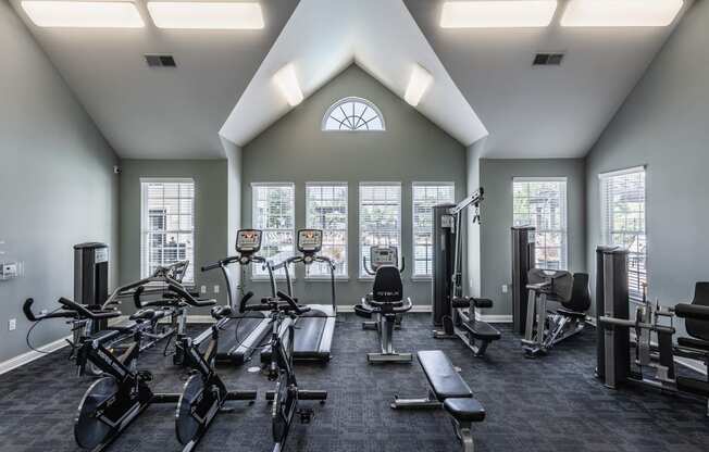a gym with exercise equipment and windows on the wall