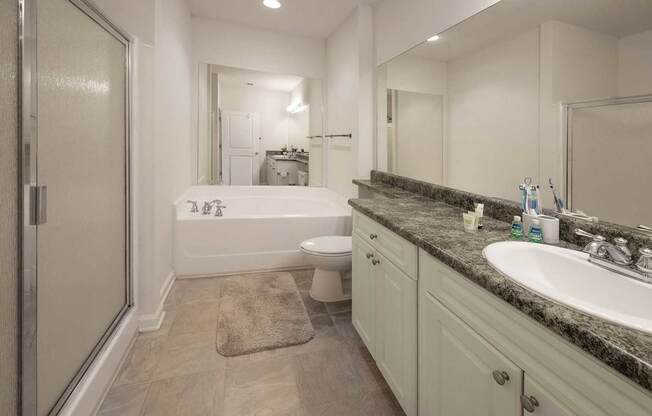 A bathroom with a tub, toilet, and sink.