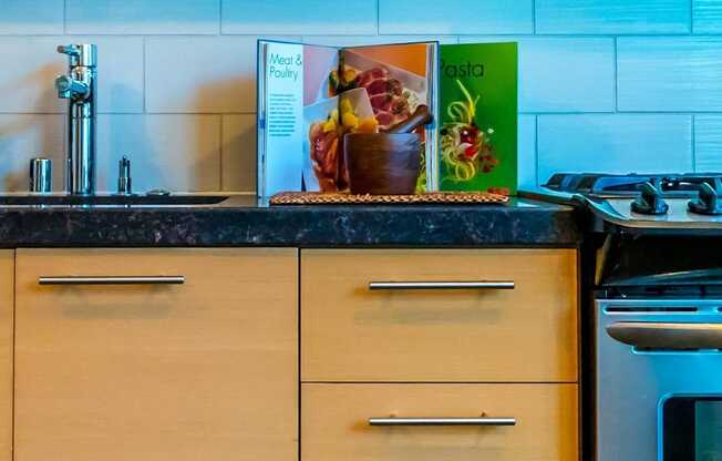 A kitchen with a black counter top and white cabinets.at Arc Light, California, 94107