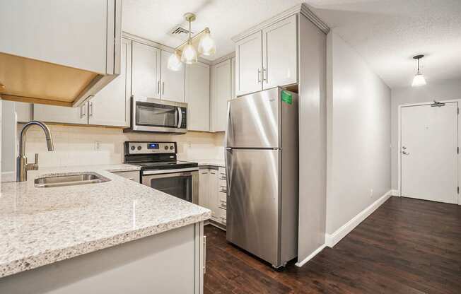 a kitchen with white cabinets and stainless steel appliances