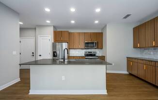 A kitchen with a black countertop and wooden cabinets.