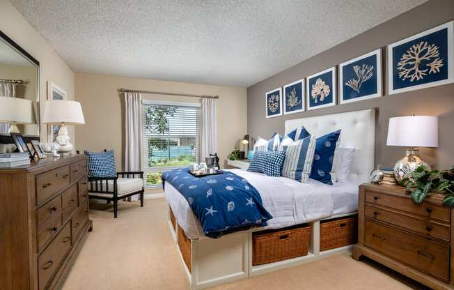 the master bedroom is decorated in blue and white and has a king sized bed and