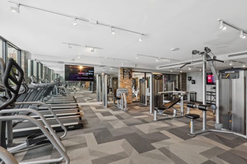 a gym with cardio equipment and weights on a checkered floor