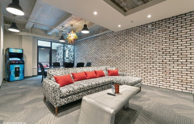 a living room with a couch and a brick wall