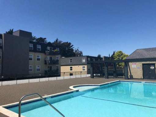 a swimming pool with an apartment building in the background