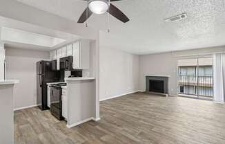 A5 kitchen and spacious living room with a fireplace and a balcony at Windridge on the Parkway apartments in Dallas, TX