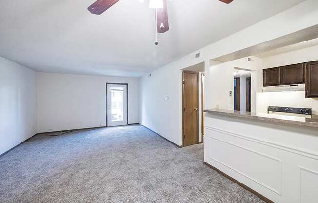 Spacious living room by kitchen with overhead light