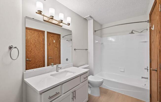 A white bathroom with a sink, toilet, and bathtub.