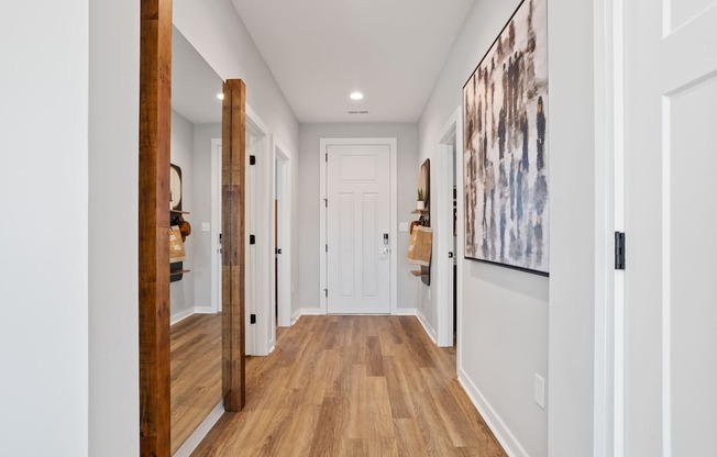 a hallway with white walls and wood-like floors in a Sanctuary at indian Creek Rental Home