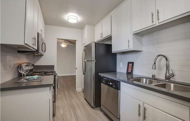 A kitchen with white cabinets and stainless steel appliances.