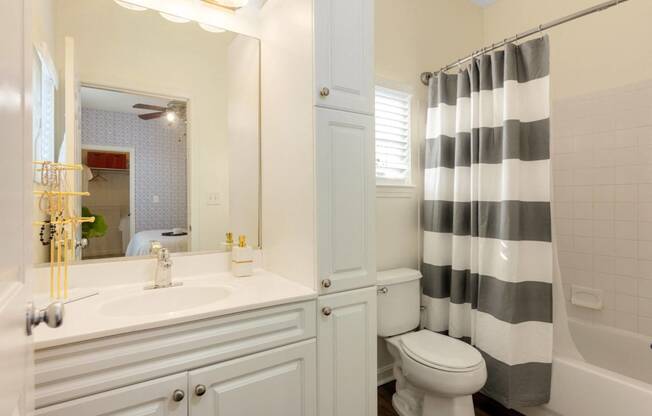 a white bathroom with a black and white shower curtain at Residences at Stevens Pond, Massachusetts