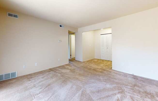 an empty living room with a door to a closet