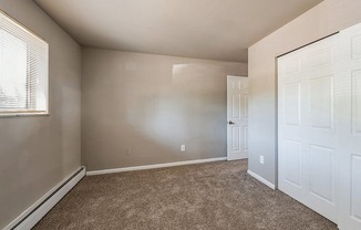 an empty bedroom with a closet and a door