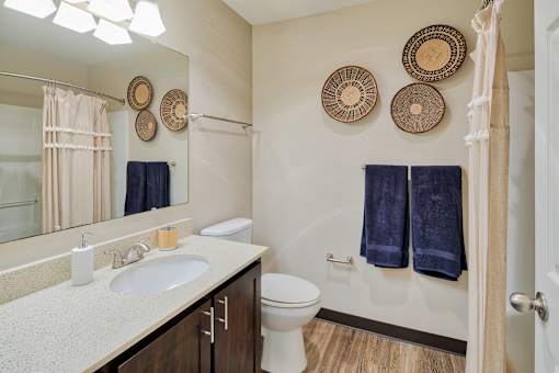 A bathroom with a white toilet, sink, and blue towels.