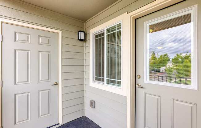 the entrance to a home with a white door and window