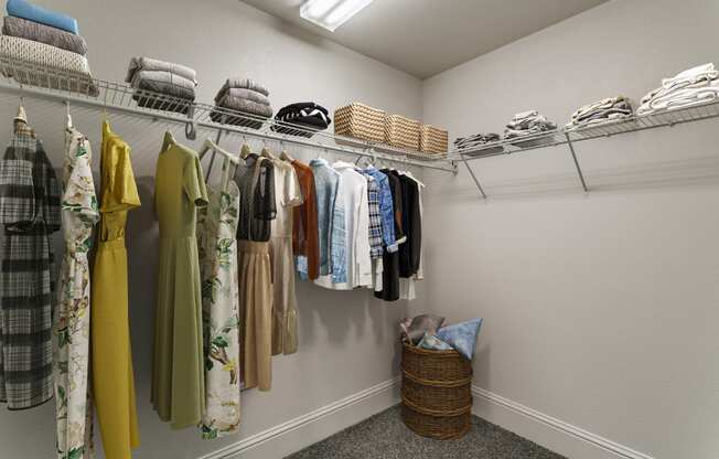 a closet with clothes hanging on a rack and a basket on the floor