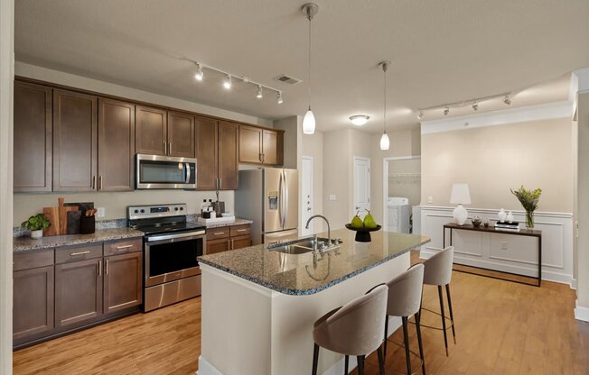 A kitchen with a granite countertop and stainless steel appliances.