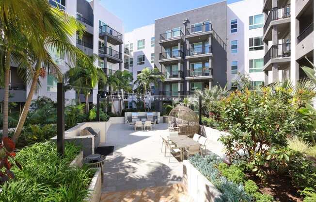 a courtyard with tables and chairs in an apartment building