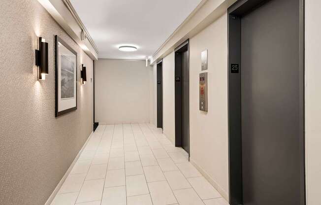 A hallway with a black door on the right and a white door on the left.
