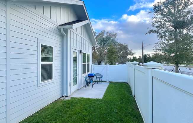 a backyard with a fence and a patio with a table and chairs at The Sophia, Venice, FL, 34275