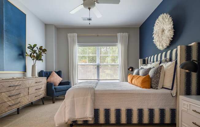 a blue and white bedroom with a bed and a ceiling fan
