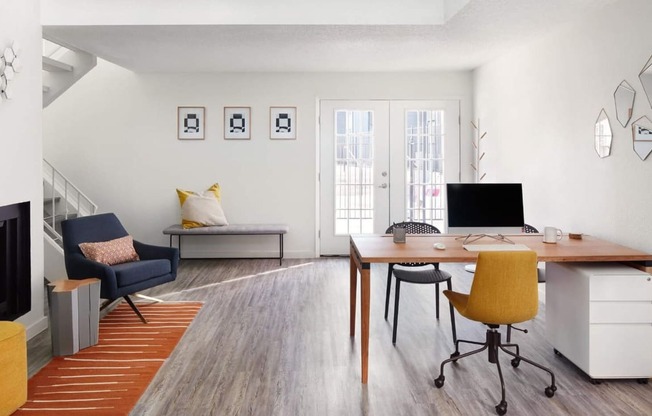 a home office with a desk and chair and a couch in the background