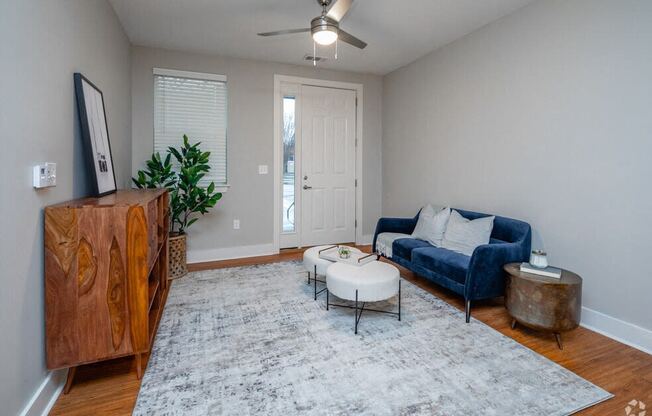 a living room with a blue couch and a ceiling fan