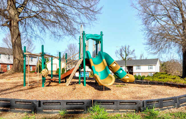 a playground with a large yellow and green slide