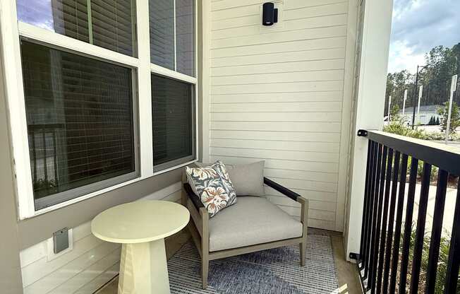 A small balcony with a white table and a sofa.