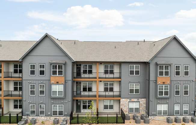 an exterior view of an apartment building with stone and gray exterior walls