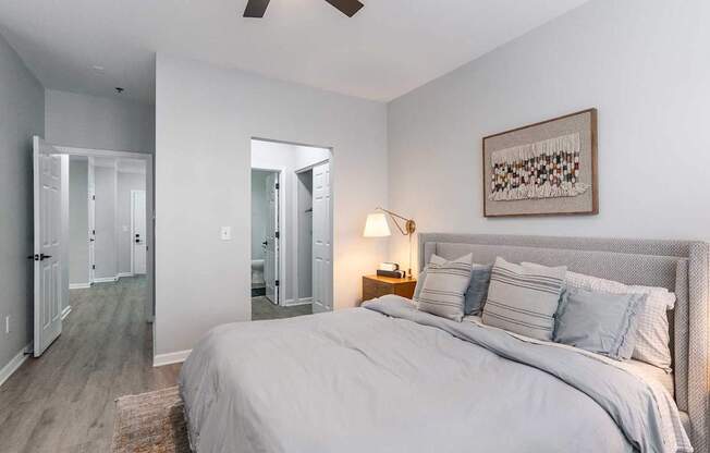 A bedroom with a large bed and a ceiling fan.