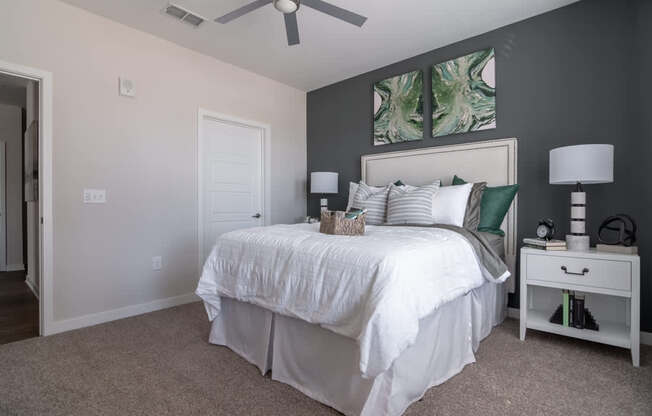 a bedroom with a white bed and a ceiling fan