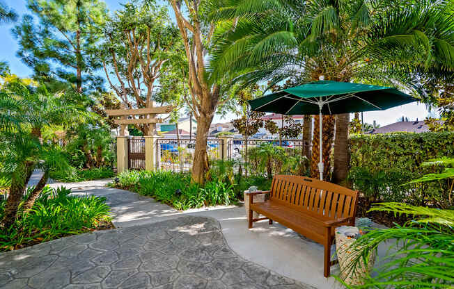 a bench with an umbrella in a garden