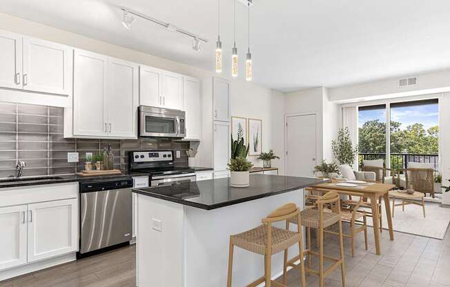 A modern kitchen with white cabinets and a black countertop.