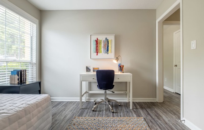 a bedroom with a desk and chair in a 555 waverly unit