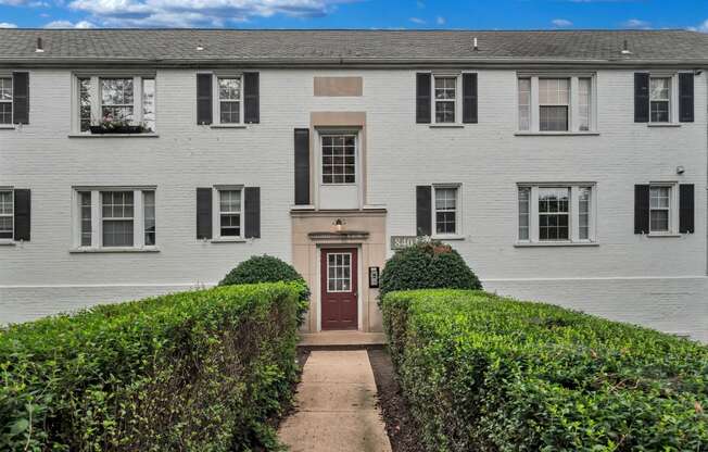 a white house with a red door and a sidewalk