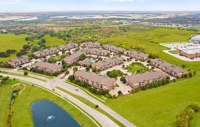 an aerial view of a subdivision with a lake in the foreground