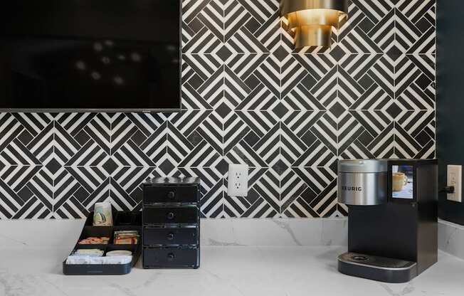 A black and white tiled wall with a pattern and a black box with a white label on it.