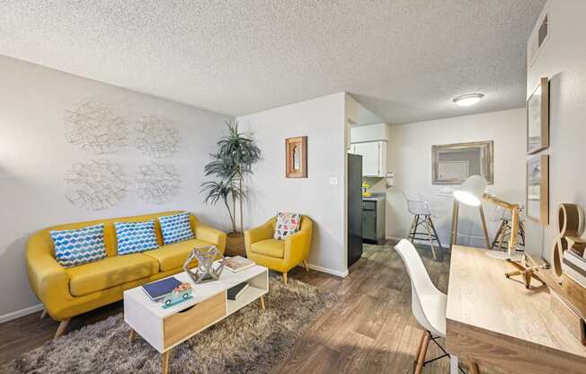 A living room with a yellow sofa and a white coffee table.