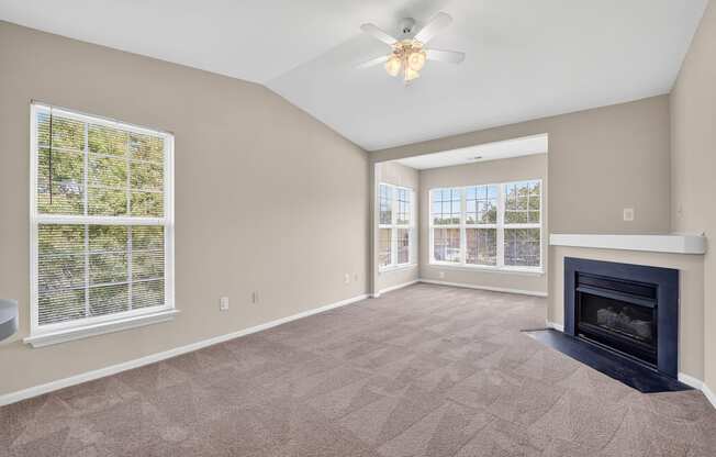 A classic 2 style living room with a fireplace and a ceiling fan.