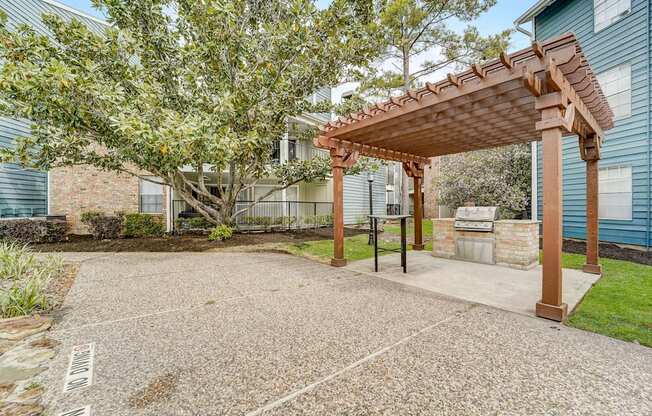 a patio with a pergola in front of a house