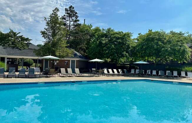 a swimming pool with chairs and umbrellas at a resort