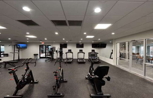 A gym with a row of stationary bikes.