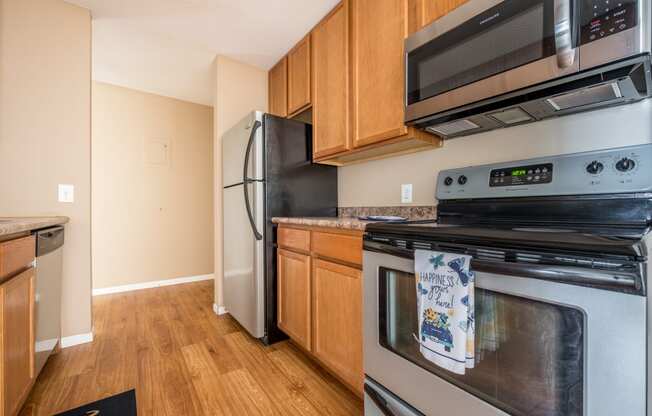 a kitchen with wood cabinets and stainless steel appliances